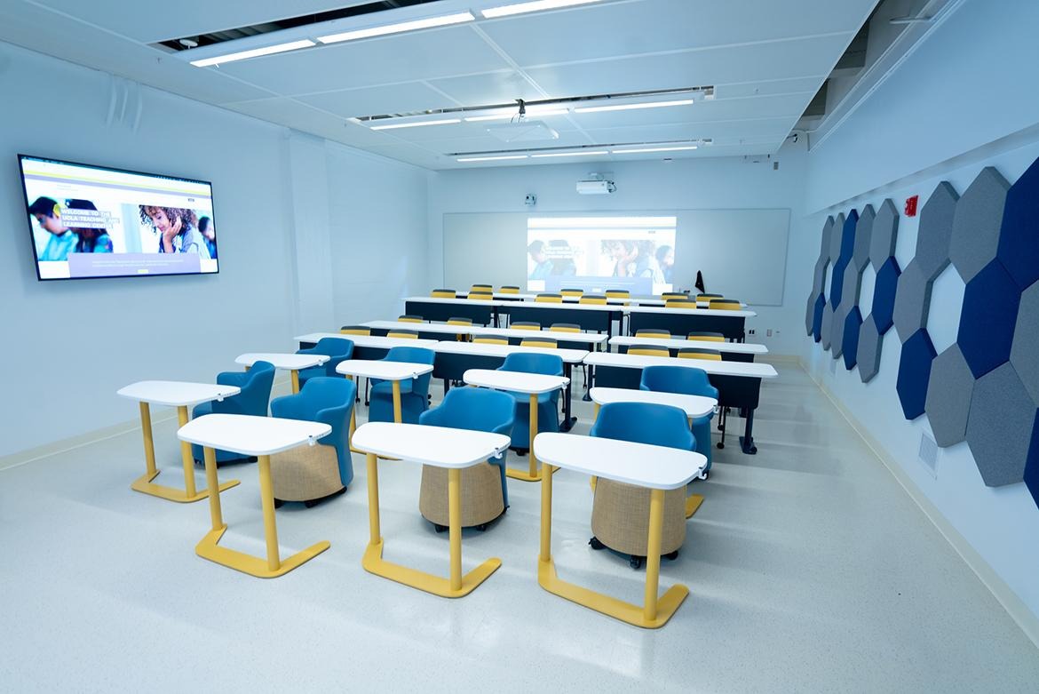 View of classroom from the front with individual desks and seats as well as two-seater desks