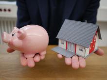 model of a house in a persons hand indicating a fix and flip of a house through fix and flip loan.