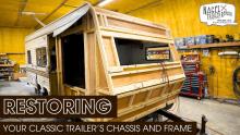 A camper trailer's wooden frame under renovation in a shop